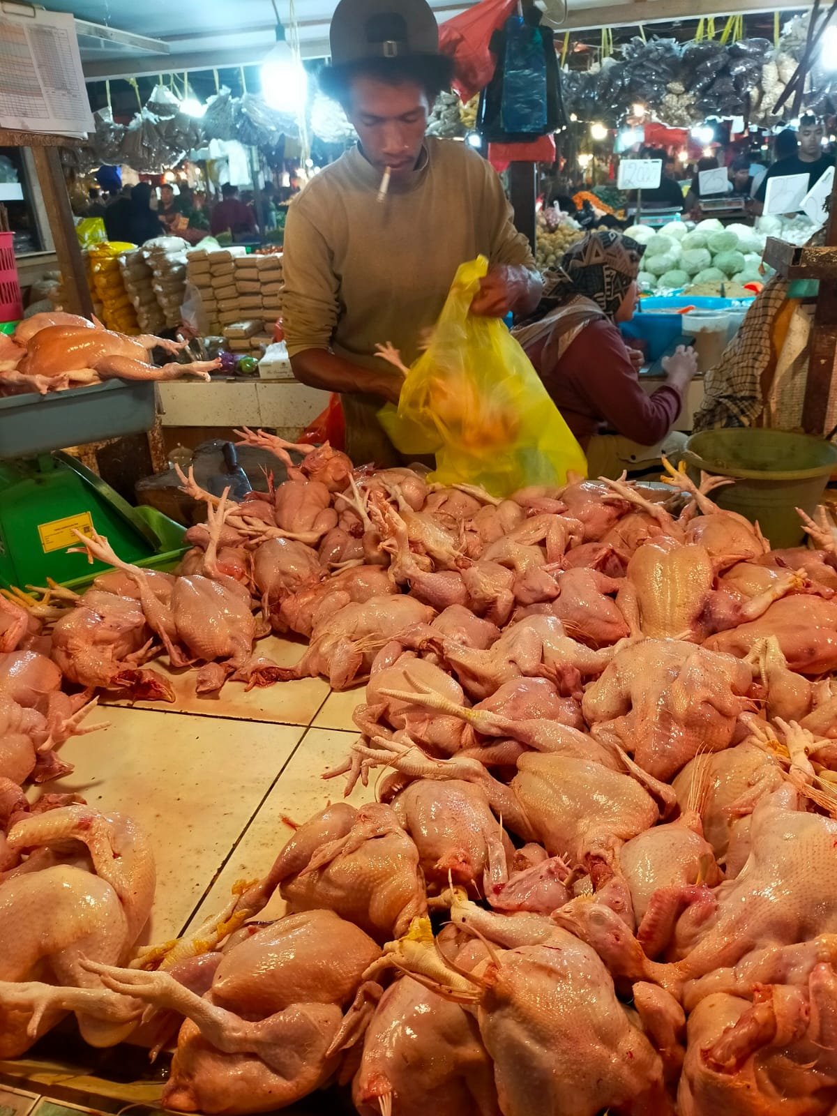 Pedagang membungkus daging ayam di Pasar Flamboyan, Pontianak, Rabu (20/8). Harga ayam bertahan di Rp28 ribu per kilogram di tengah fluktuasi kebutuhan pokok.