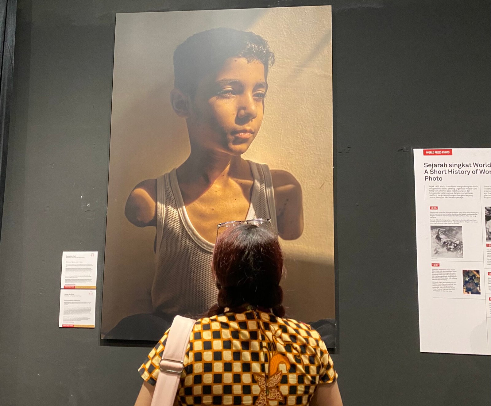 Seorang pengunjung sedang melihat foto yang dianugerahi sebagai The 2025 World Press Photo of the Year di World Press Photo Exhibition yang Digelar di Port 99 Pontianak.