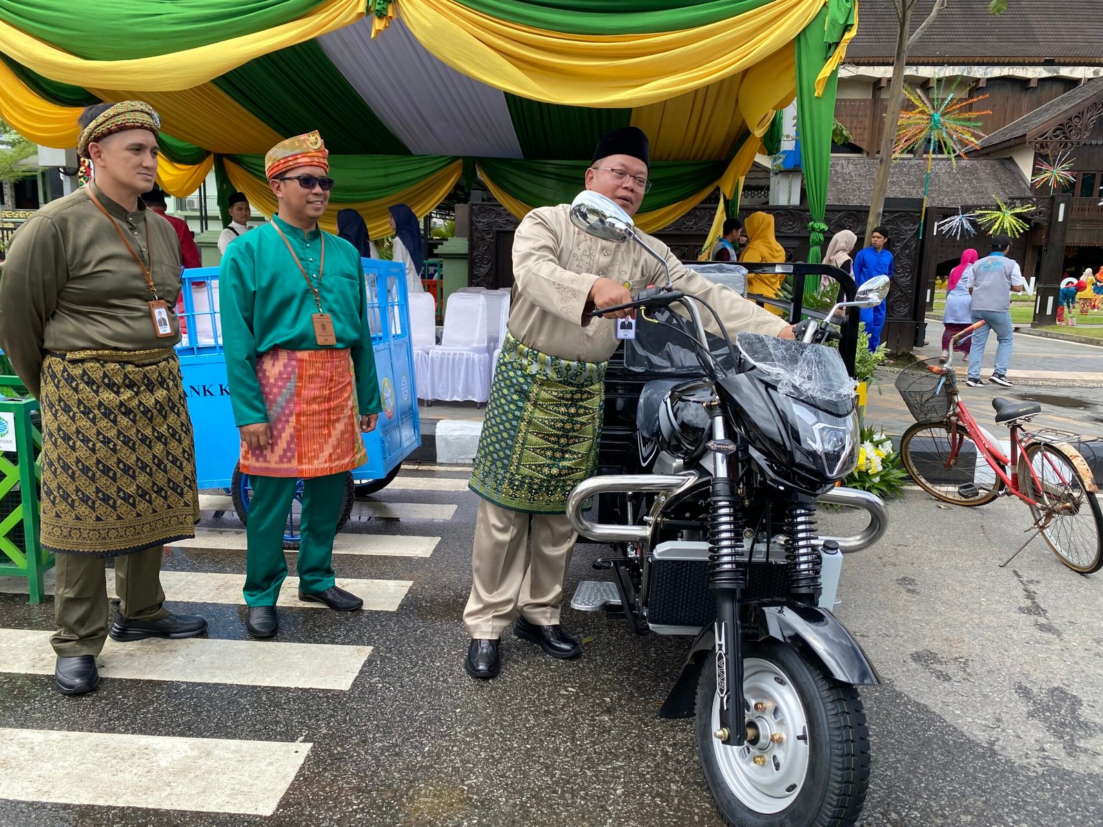 Dirut Bank Kalbar, Rokidi saat mencoba menghidupkan mesin kendaraan roda tiga yang dihadiahkan untuk Kota Pontianak. Foto: Yulia Ramadhiyanti/klikwartaku
