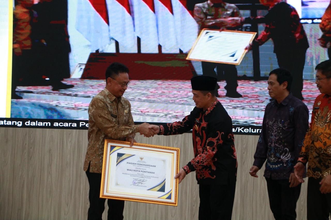 Wali Kota Pontianak Edi Rusdi Kamtono menerima piagam penghargaan atas dukungan pembentukan Posbakum di tingkat kelurahan. Foto: Dok. Prokopim Pemkot Pontianak
