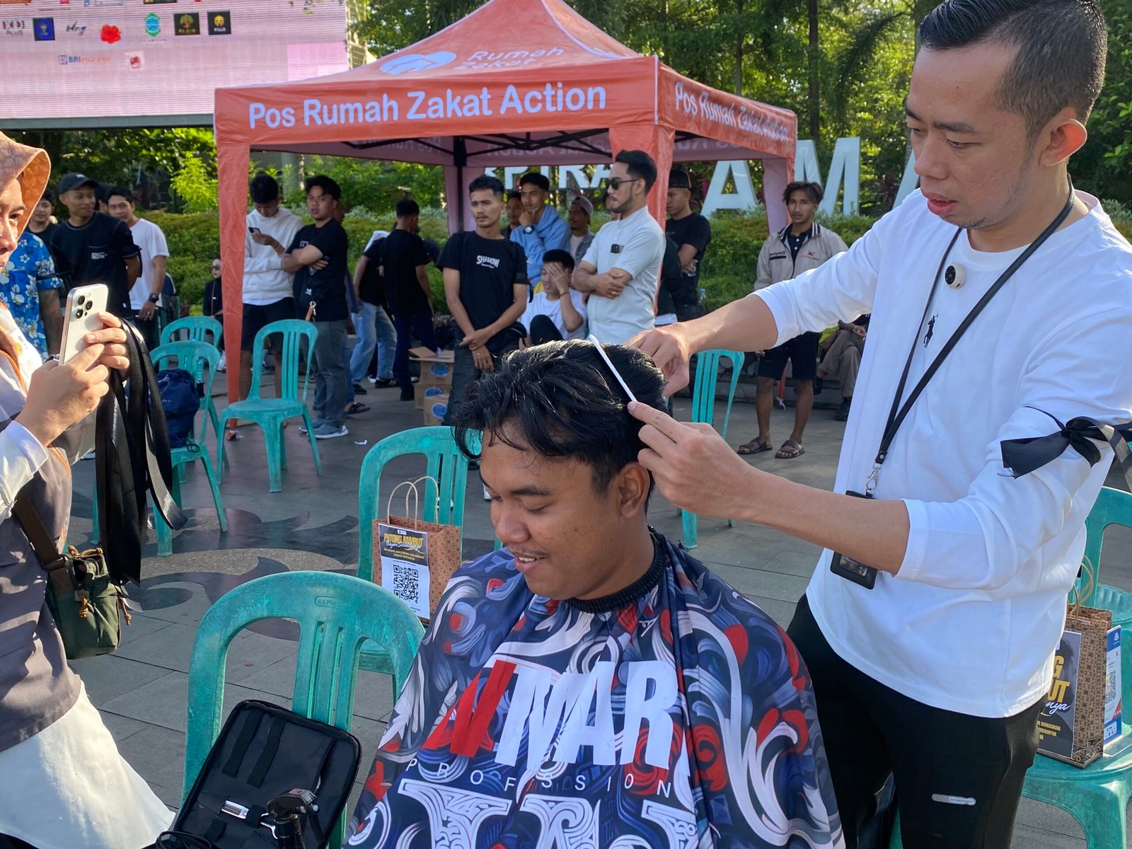 Branch Manager Rumah Zakat ikut mencukur rambut warga di aksi cukur amal. Foto: Yulia Ramadhiyanti/Klikwartaku