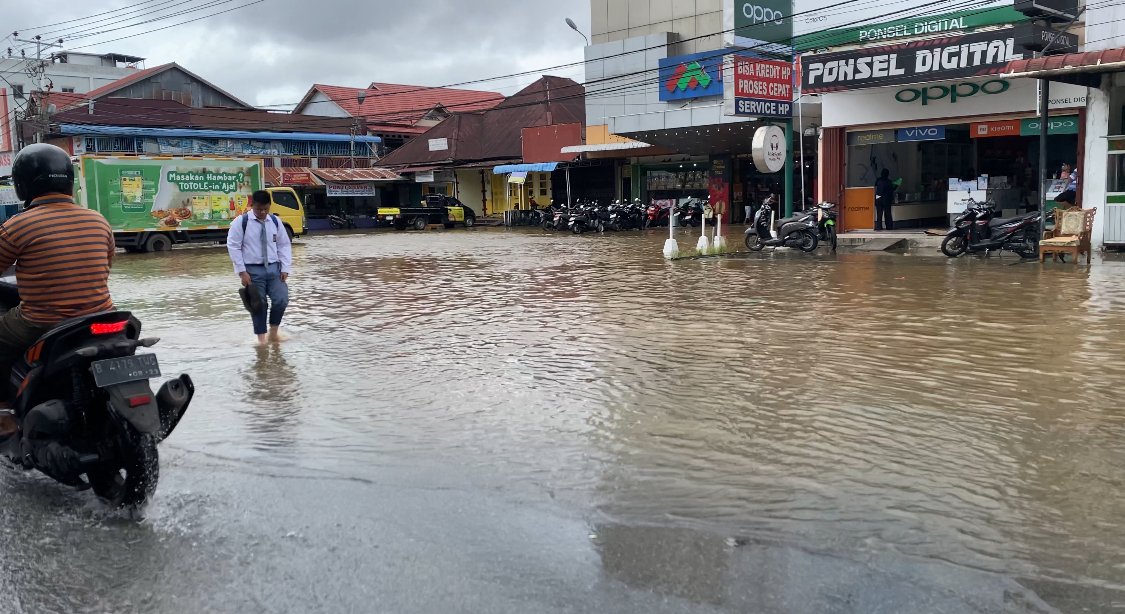 Seorang siswa sedang berjalan kaki melewati banjir di Jalan Gusti Hamzah Pontianak. Foto: Yulia Ramadhiyanti/klikwartaku