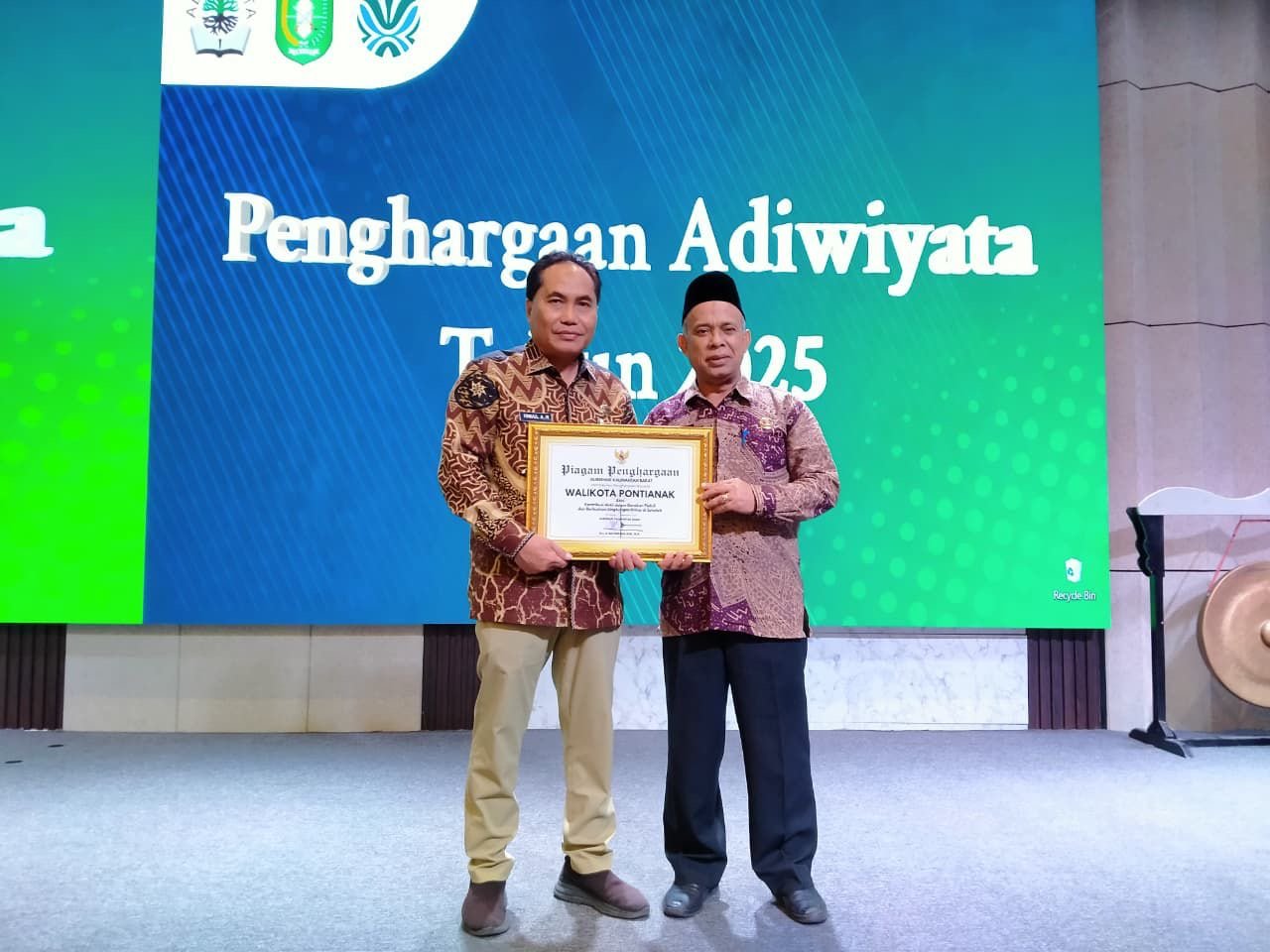 Asisten Pemerintahan dan Kesra Ismail dan Kepala Dinas Lingkungan Kota Pontianak Syarif Usmulyono, usai menerima piagam penghargaan Adiwiyata Kalbar 2025. Foto: Dok. Prokopim Pemkot Pontianak