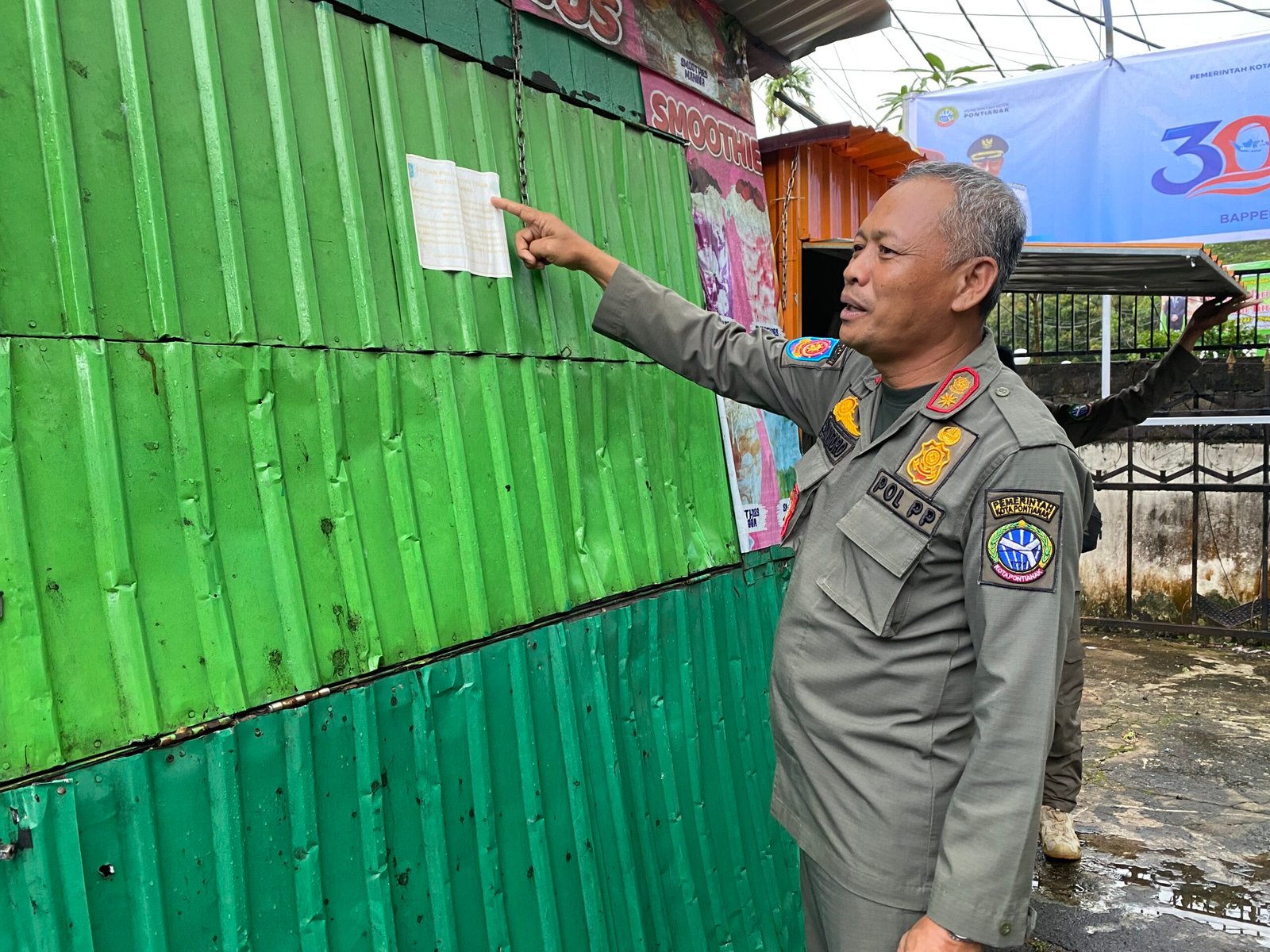 Kasatpol PP Pontianak, Ahmad Sudiyantoro, menunjukkan stiker peringatan yang dipasang di gerobak pedagang. Foto: Yulia Ramadhiyanti/klikwartaku