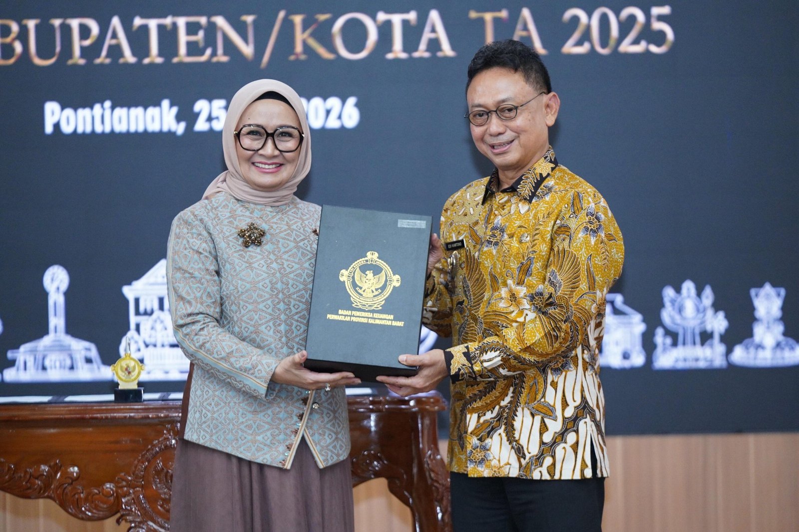 Kepala BPK Perwakilan Provinsi Kalbar, Sri Haryati menyerahkan laporan hasil pemeriksaan atas laporan keuangan pemerintah daerah kepada Wali Kota Pontianak Edi Rusdi Kamtono. Foto: Dok. Prokopim Pemkot Pontianak