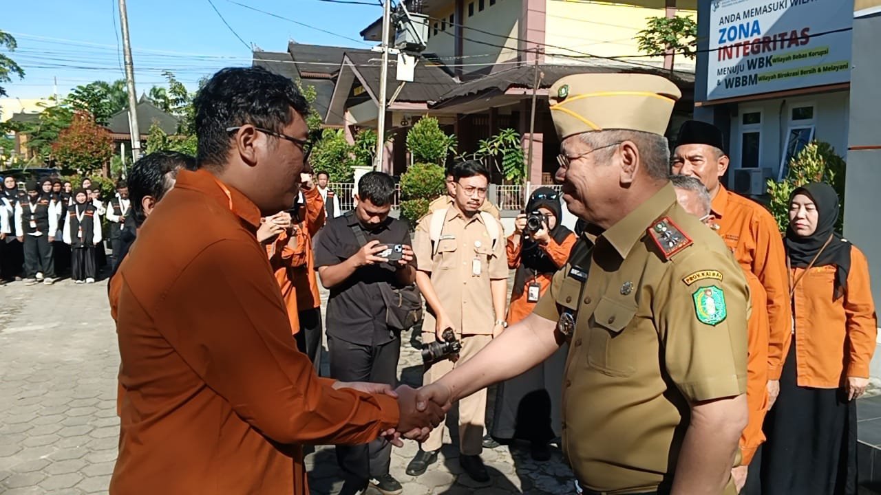 Sekda Kalbar, Harisson, mengalungkan tanda pengenal ke petugas Sensus Ekonomi 2026. Foto: Yulia Ramadahiyanti/klikwartaku