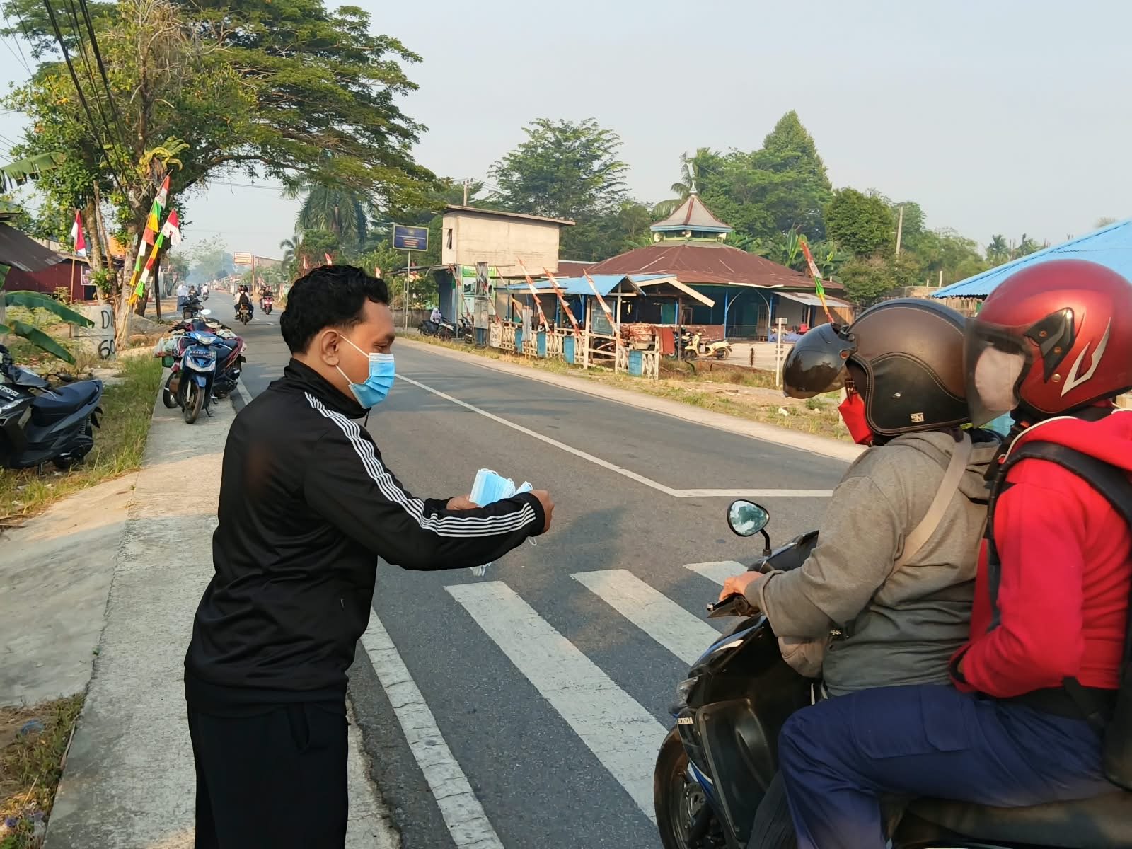 Warga jaga warga, seorang pemuda bagikan masker gratis ke pengendara di Kubu Raya. Foto: Dok. Istimewa