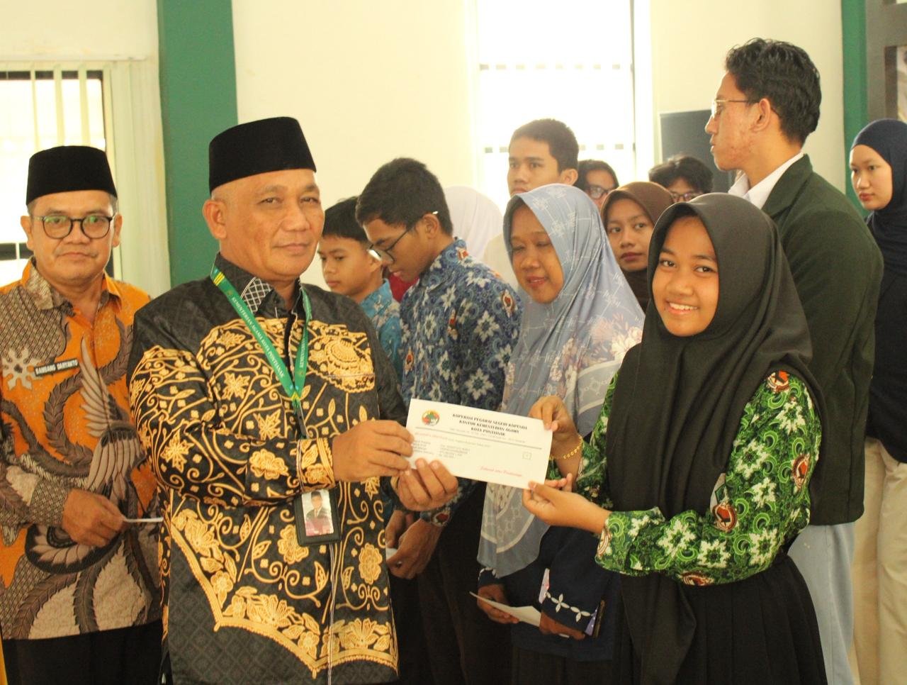 Ruslan turut menyerahkan beasiswa Kopenda Kemenag Pontianak kepada putra-putri anggota. Foto: Dok. Kemenag Pontianak